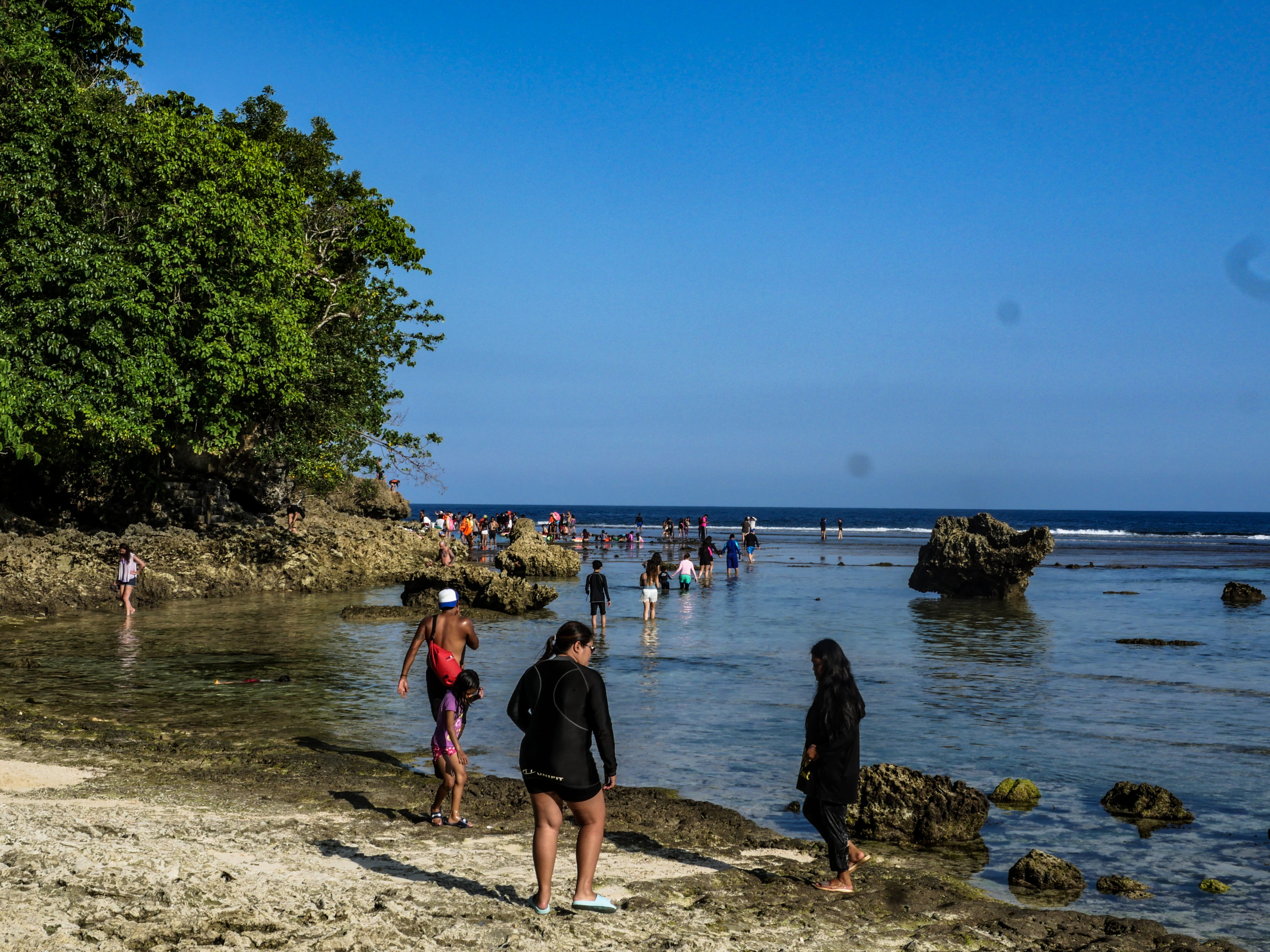 people walking over a trail towards the magpupungko rock pools in siargao island